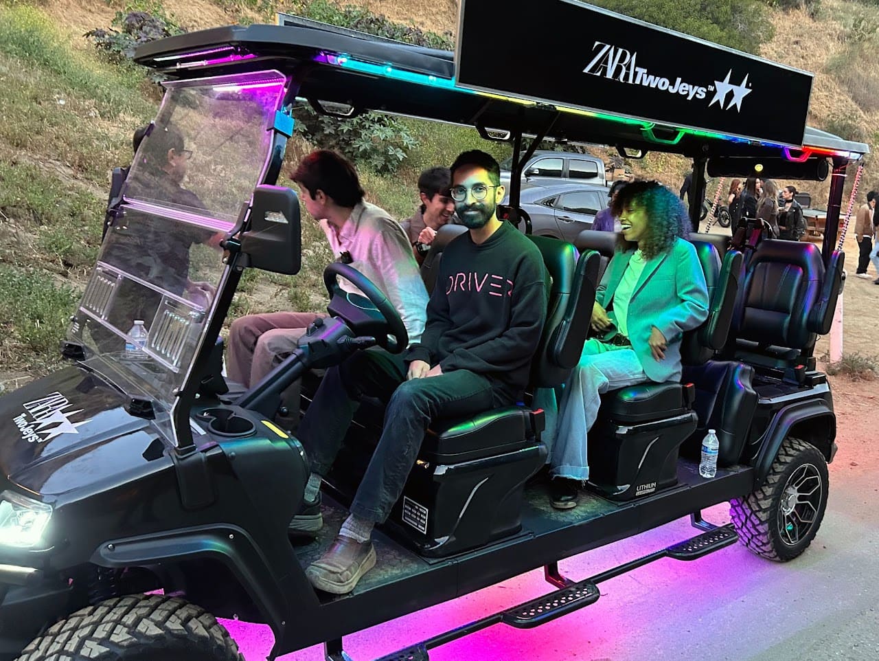 Guests riding a ZARA x TwoJeys branded shuttle cart at the influencer party in the Hollywood Hills