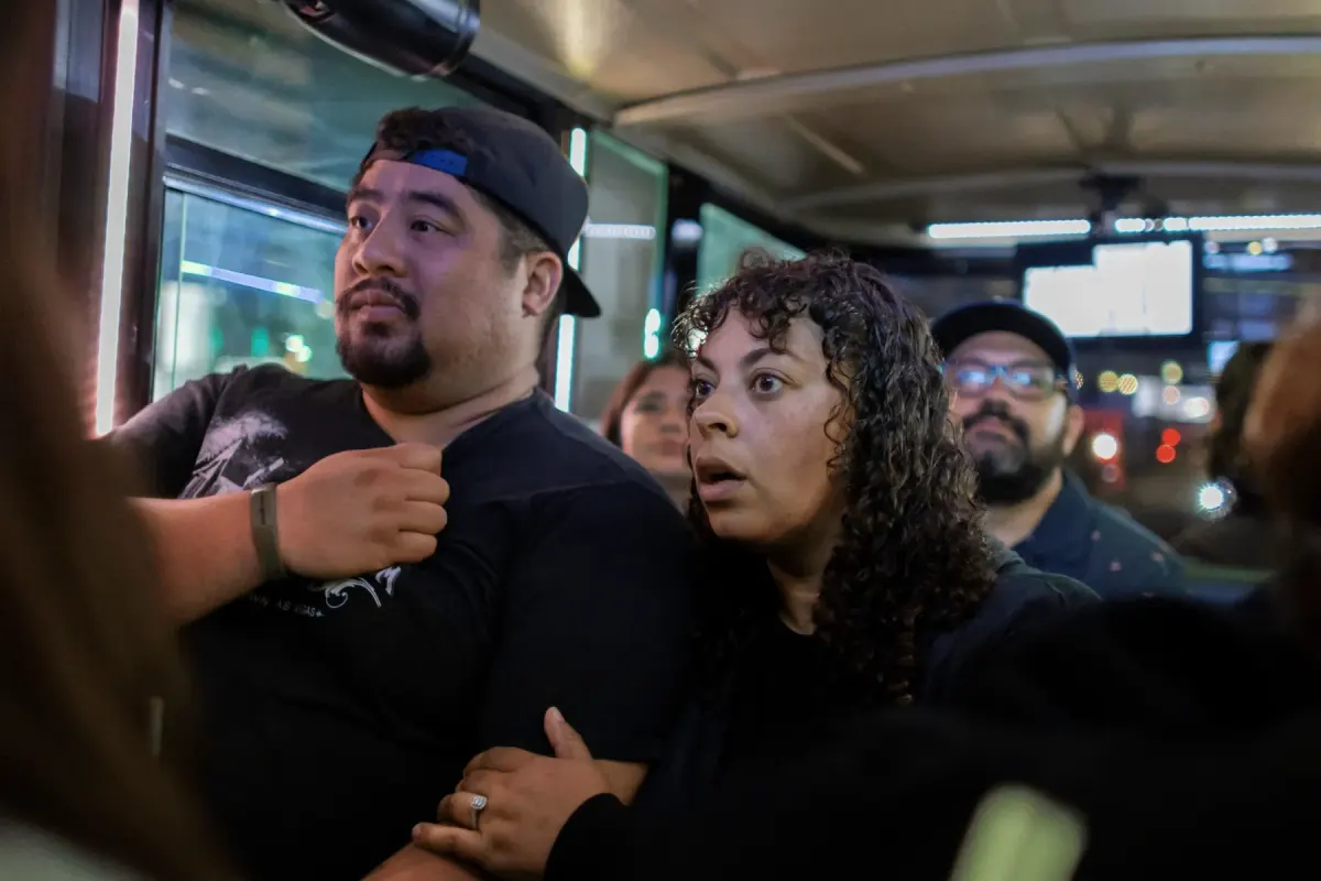 Two guests looking on with startled expressions inside the tour bus